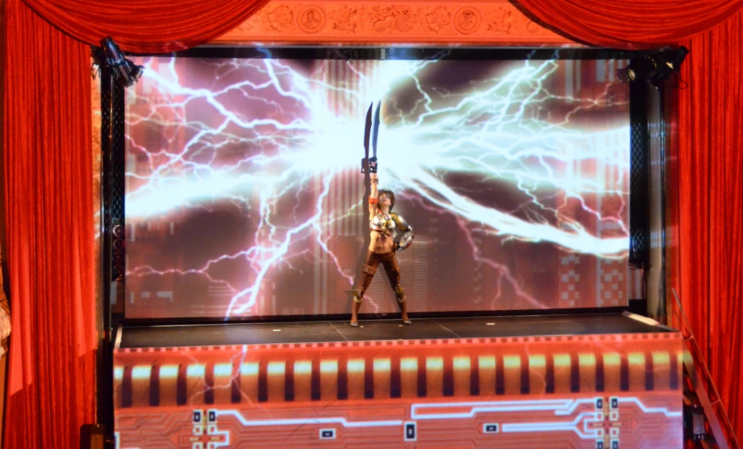 Costumed warrior raising a sword amid projected lightning at the Qualcomm Snapdragon launch