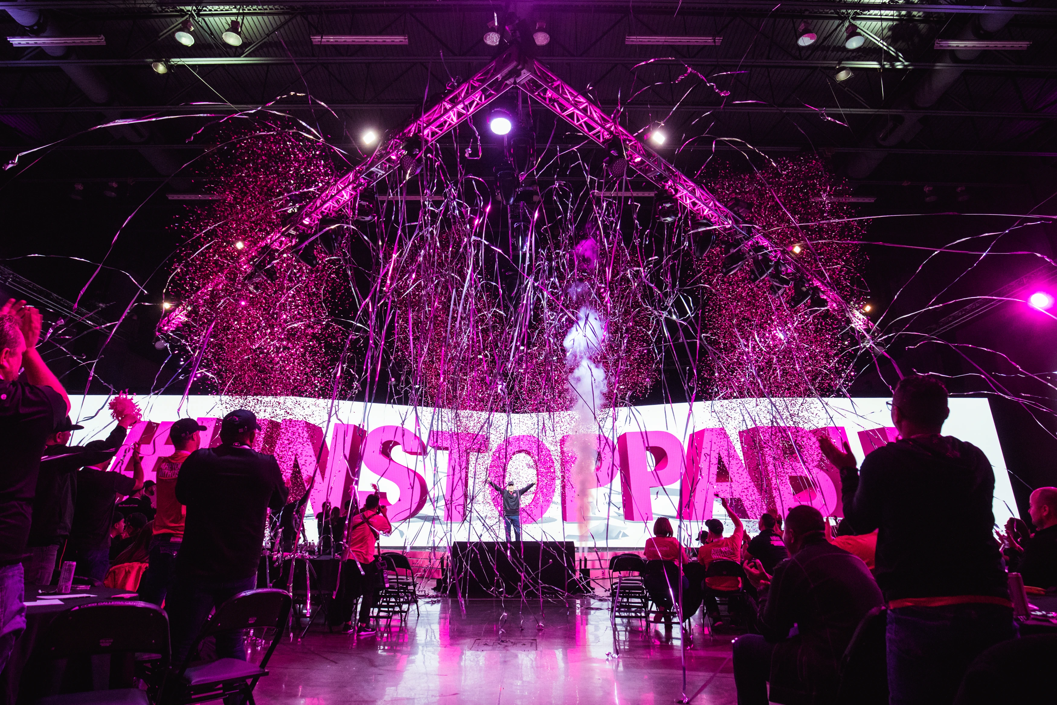 Silver streamers and magenta confetti burst over the T-Mobile #UNSTOPPABLE Tour stage