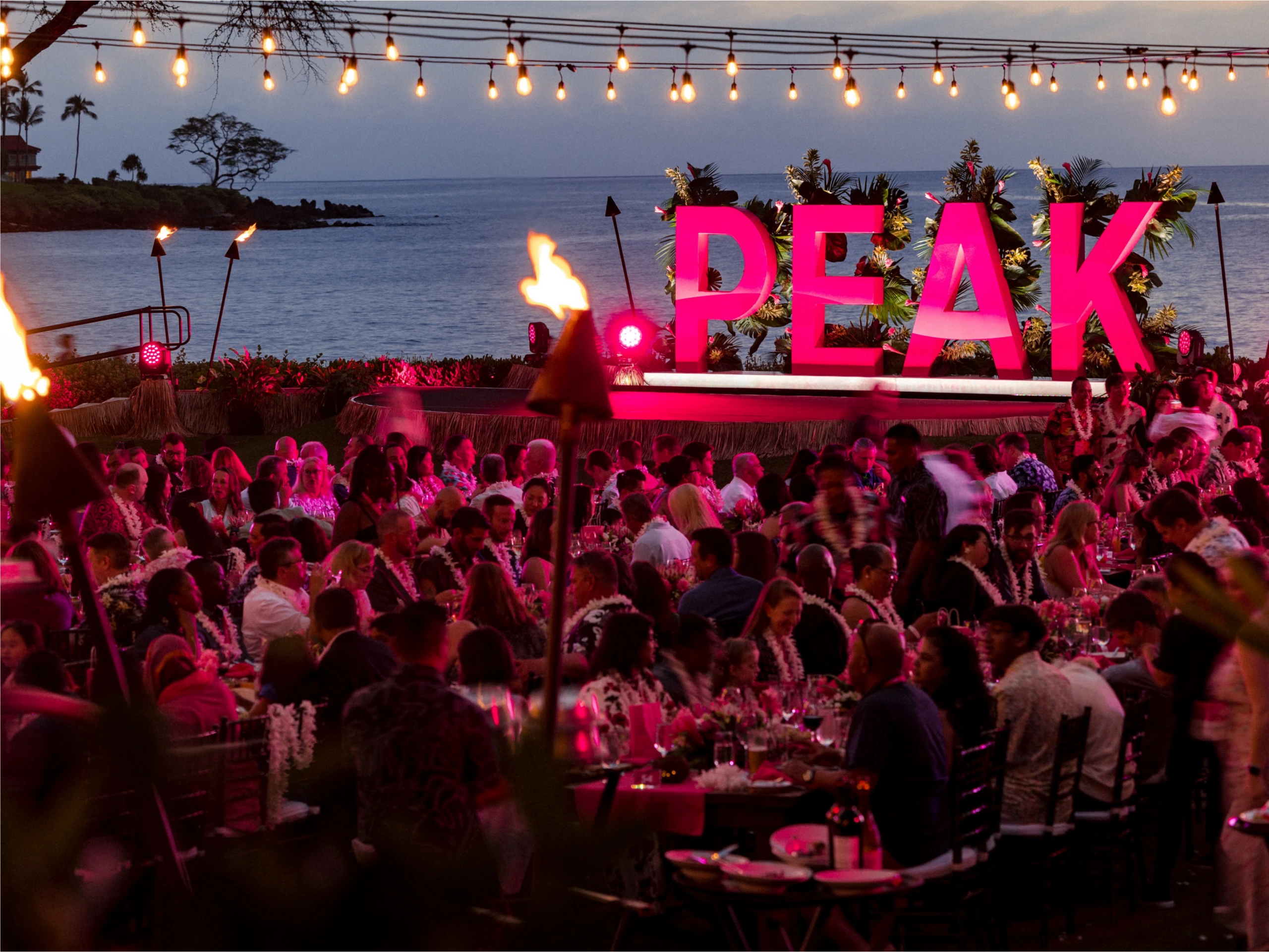 Oceanfront T-Mobile PEAK dinner in Hawaii with tiki torches and giant pink PEAK letters