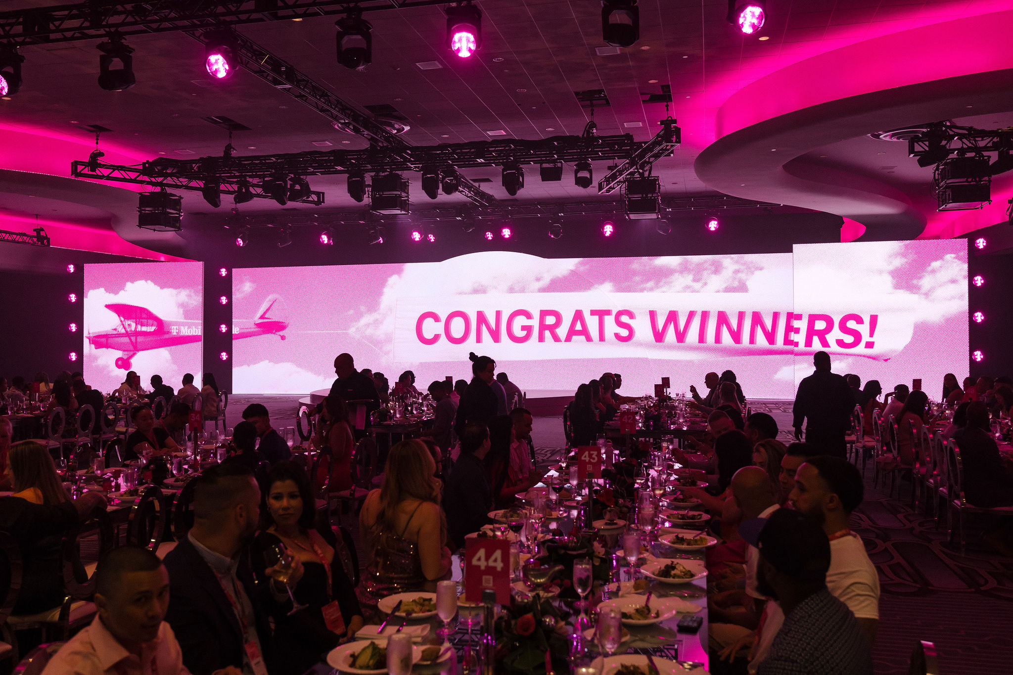 Winners Circle gala dinner under a wide screen reading Congrats Winners