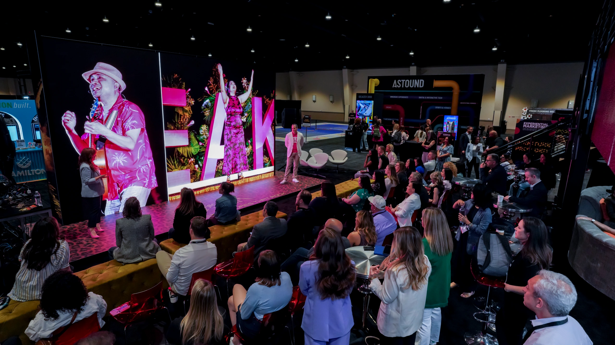 Attendees watch the T-Mobile session on a show-floor stage at Experiential Marketing Summit