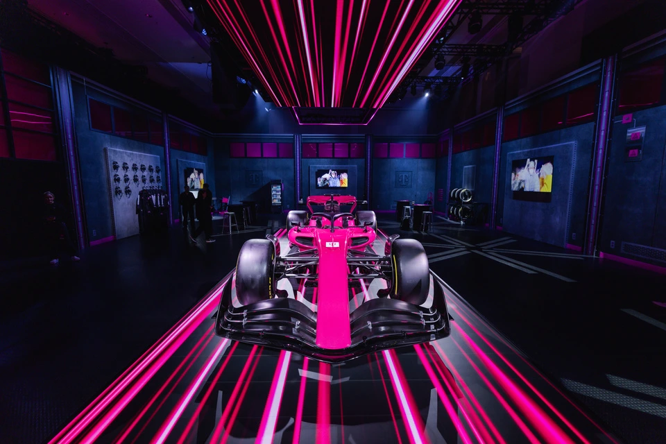 Neon pink T-Mobile F1 show car on display amid streaks of magenta light