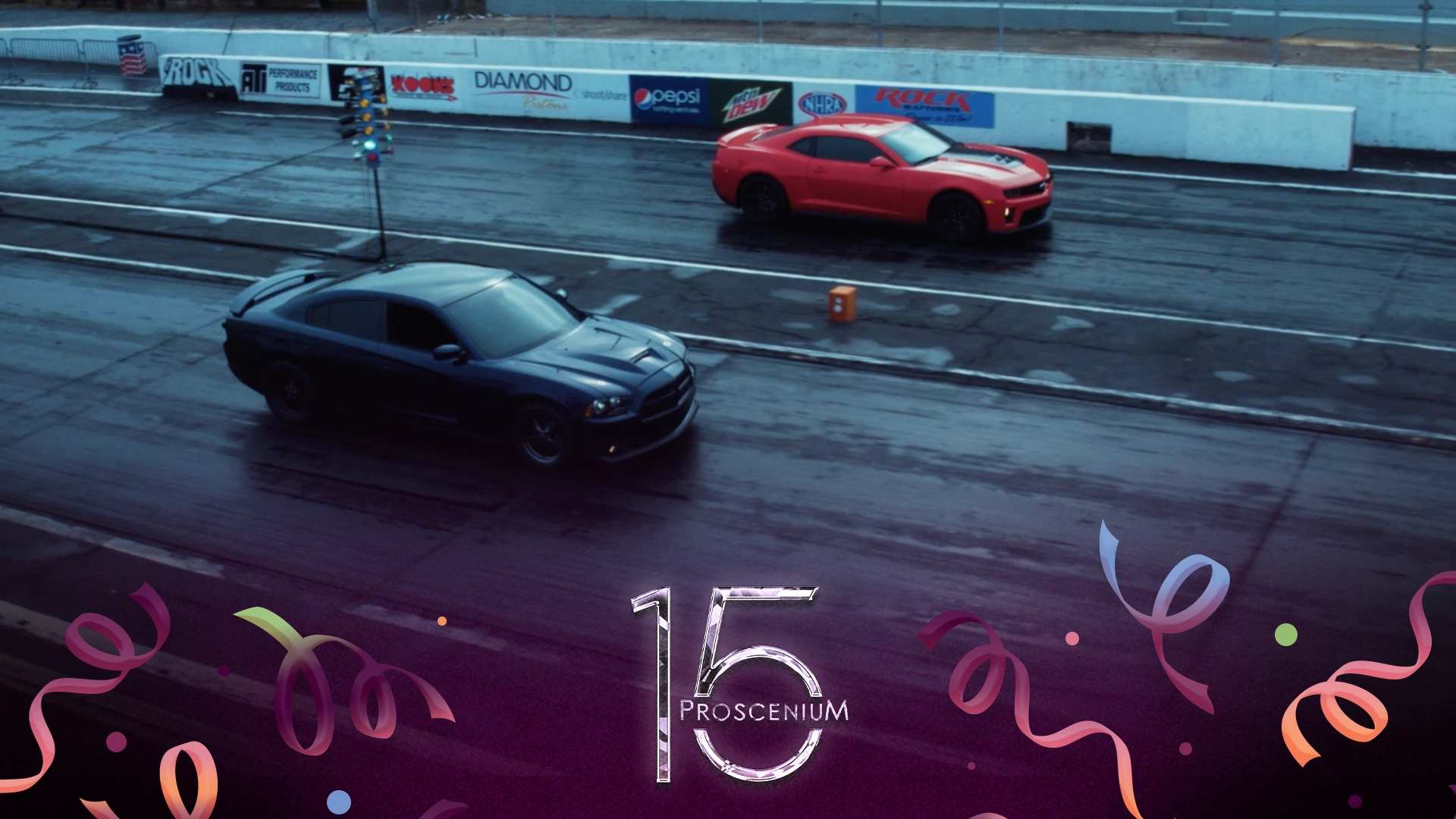 Two cars lined up on a wet drag strip for Ortho event footage, with a Proscenium 15 anniversary mark